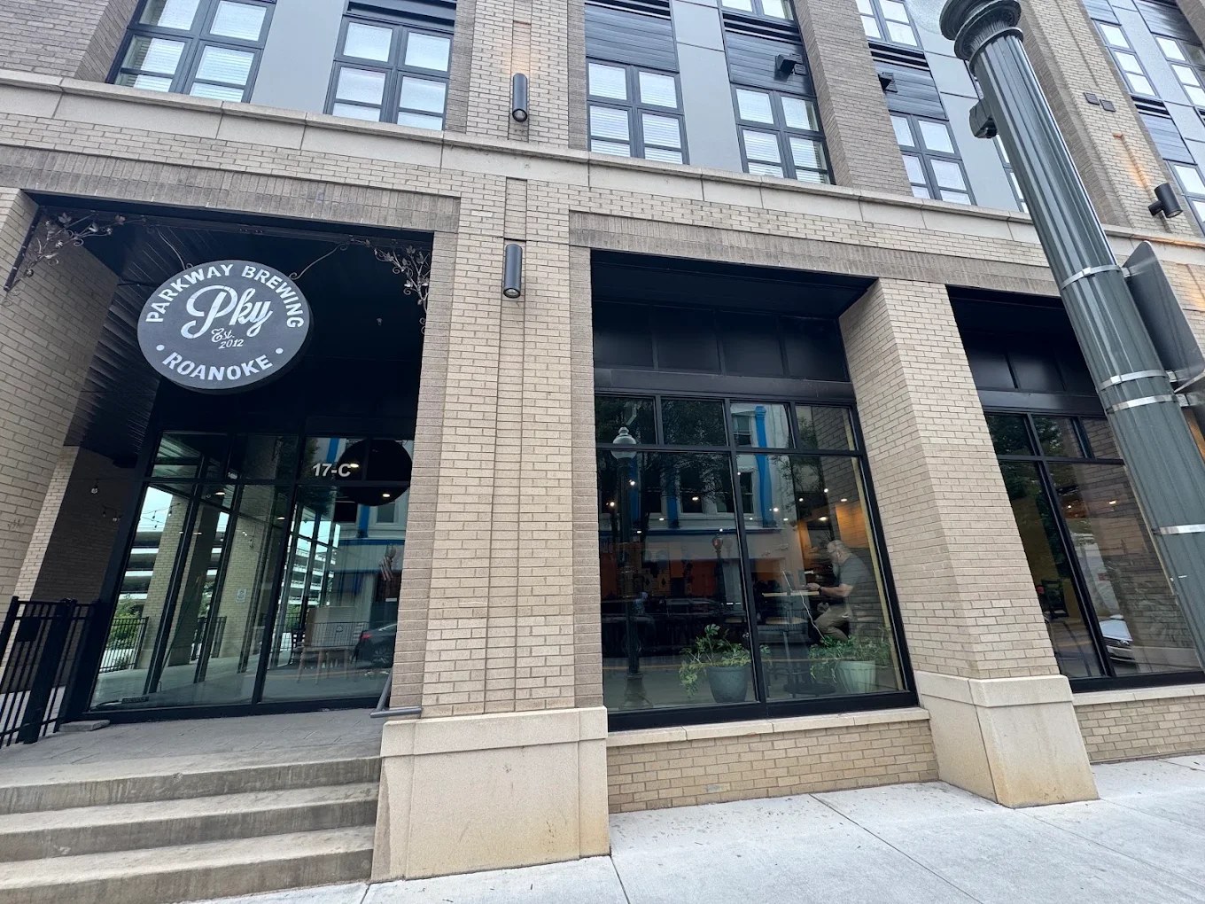 The Parkway Brewing downtown Roanoke tap room from the street, its round sign hanging over the entrance